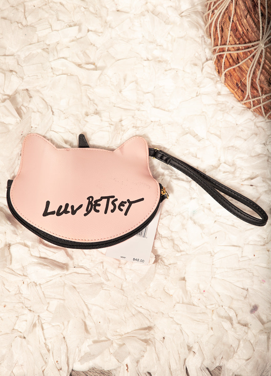 Pink cat-shaped pouch with 'LUV BETSY' text on a white textured surface