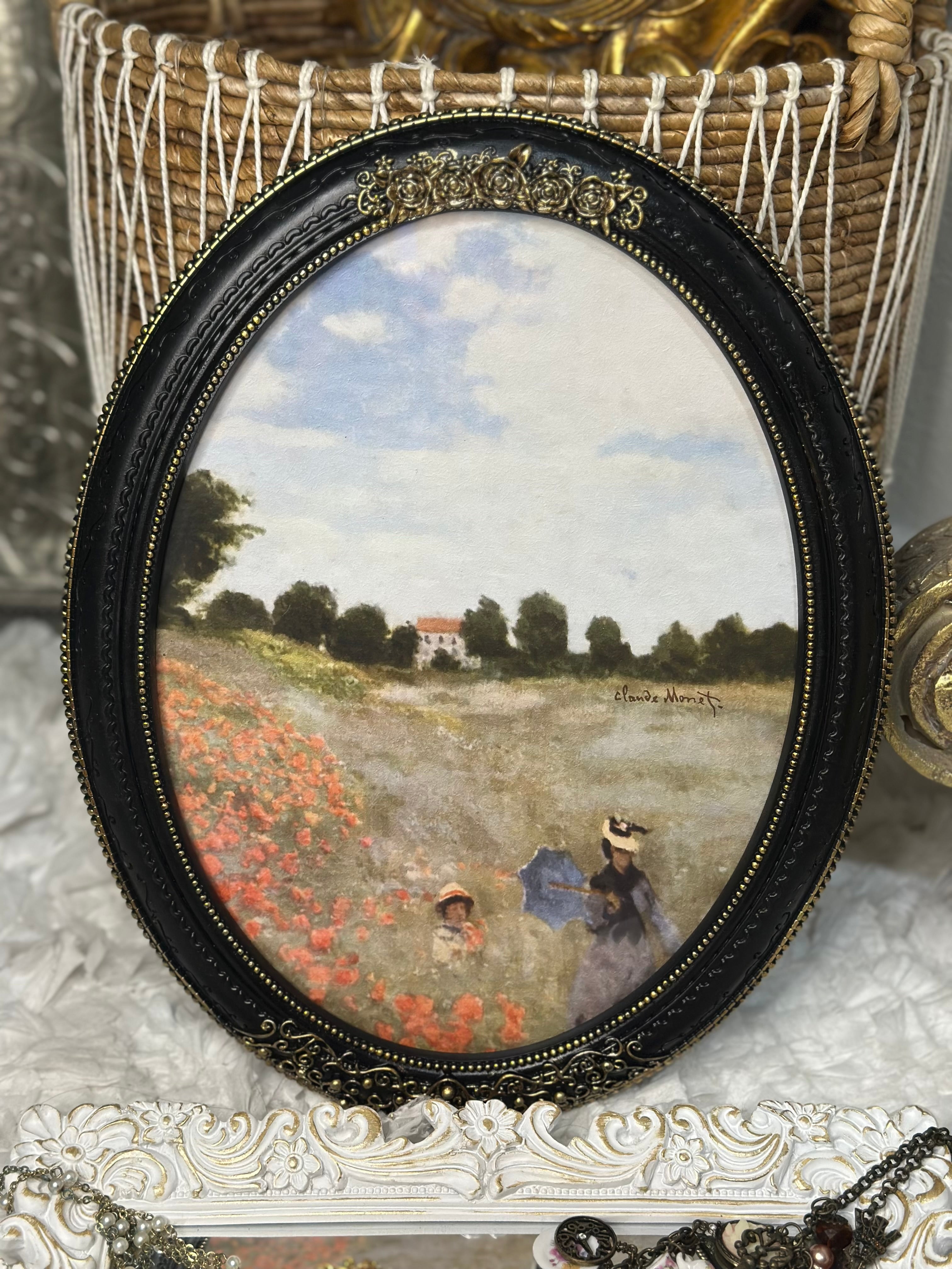 Black and gold oval picture frame with Monet print, vintage Art Deco wall decor.
