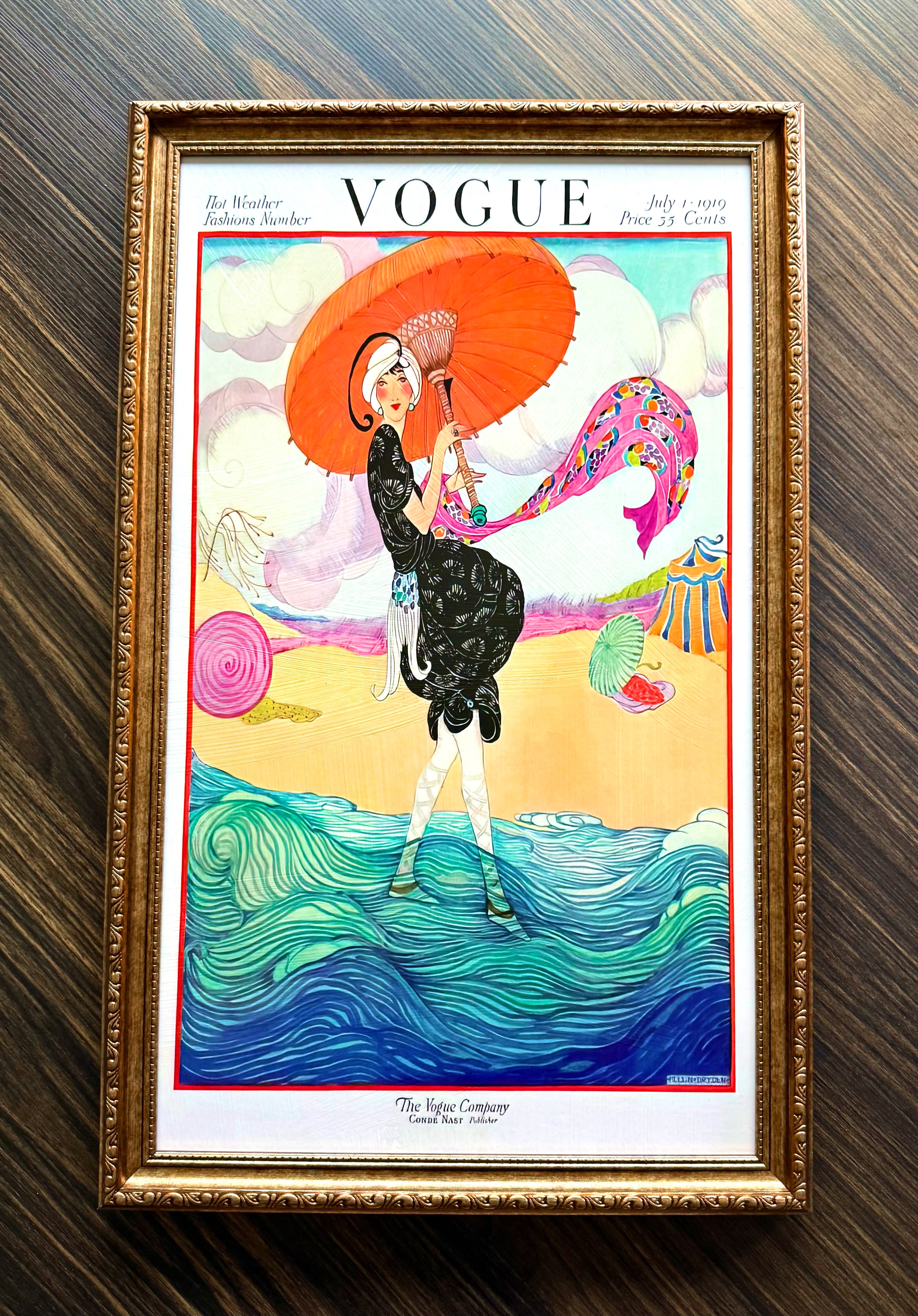 Framed Vogue Hot Weather 1919 cover art featuring woman with parasol by the sea in ornate antique gold frame wall décor.