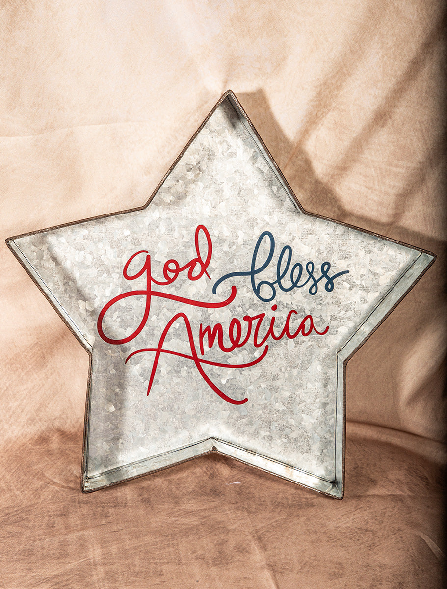 Star-shaped decorative item with 'God Bless America' text on a wooden surface
