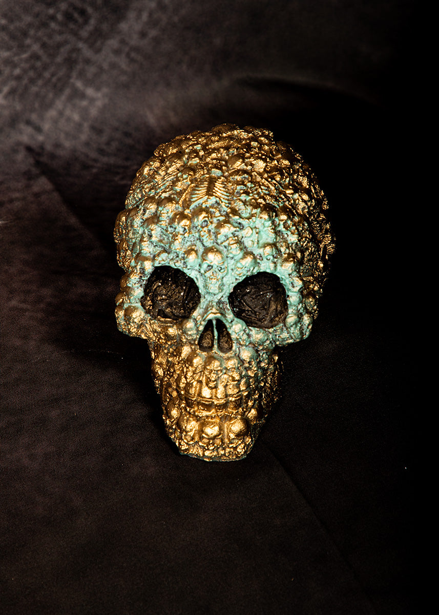 Gold skull sculpture with patina finish, gothic alchemy-inspired home decor accent.