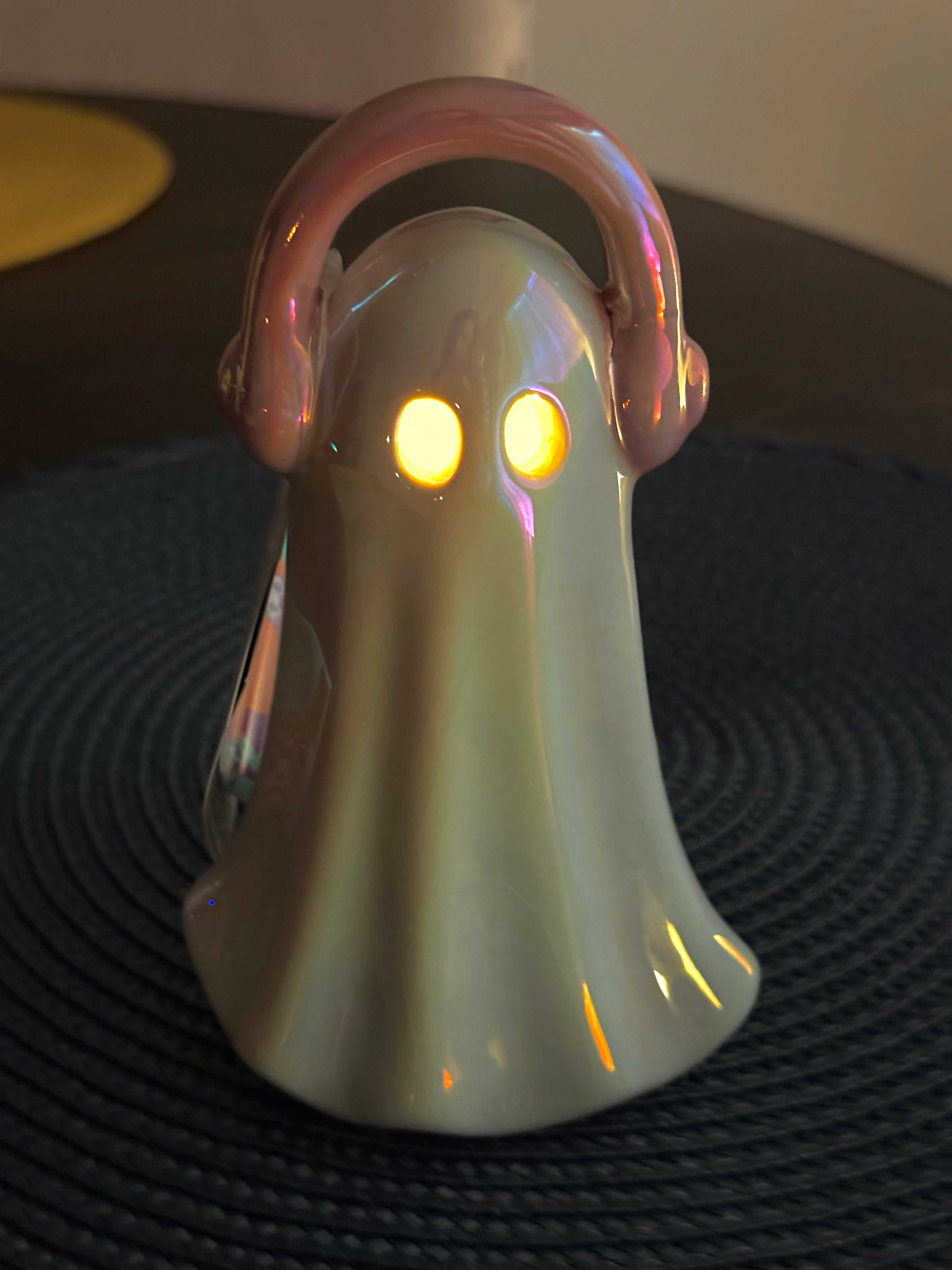 Holographic ghost figurine wearing pink headphones with LED light, fun retro music decor for Halloween display.