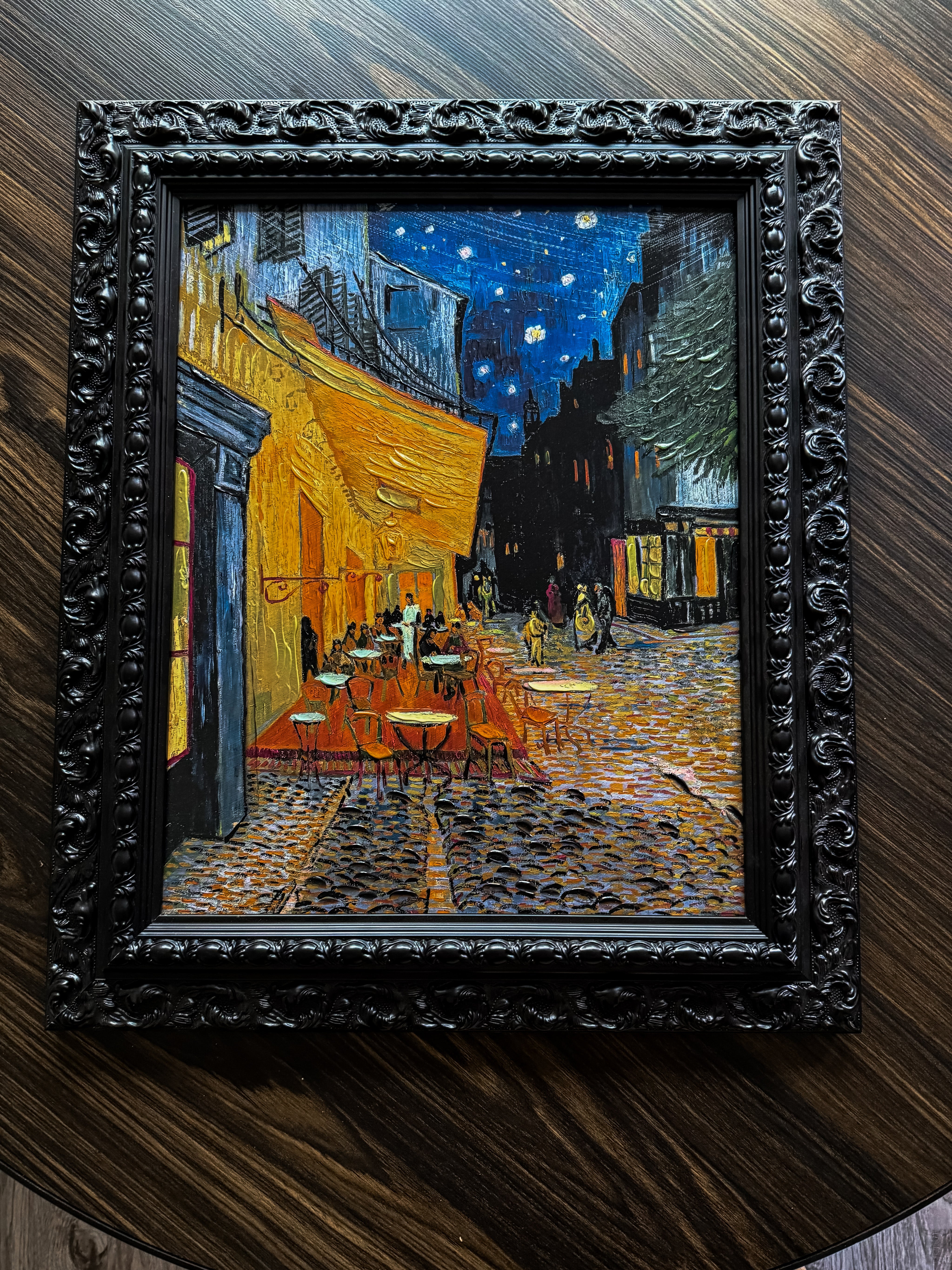 Ornate black baroque frame showcasing a textured café night canvas with raised brushstrokes and dramatic European street ambiance