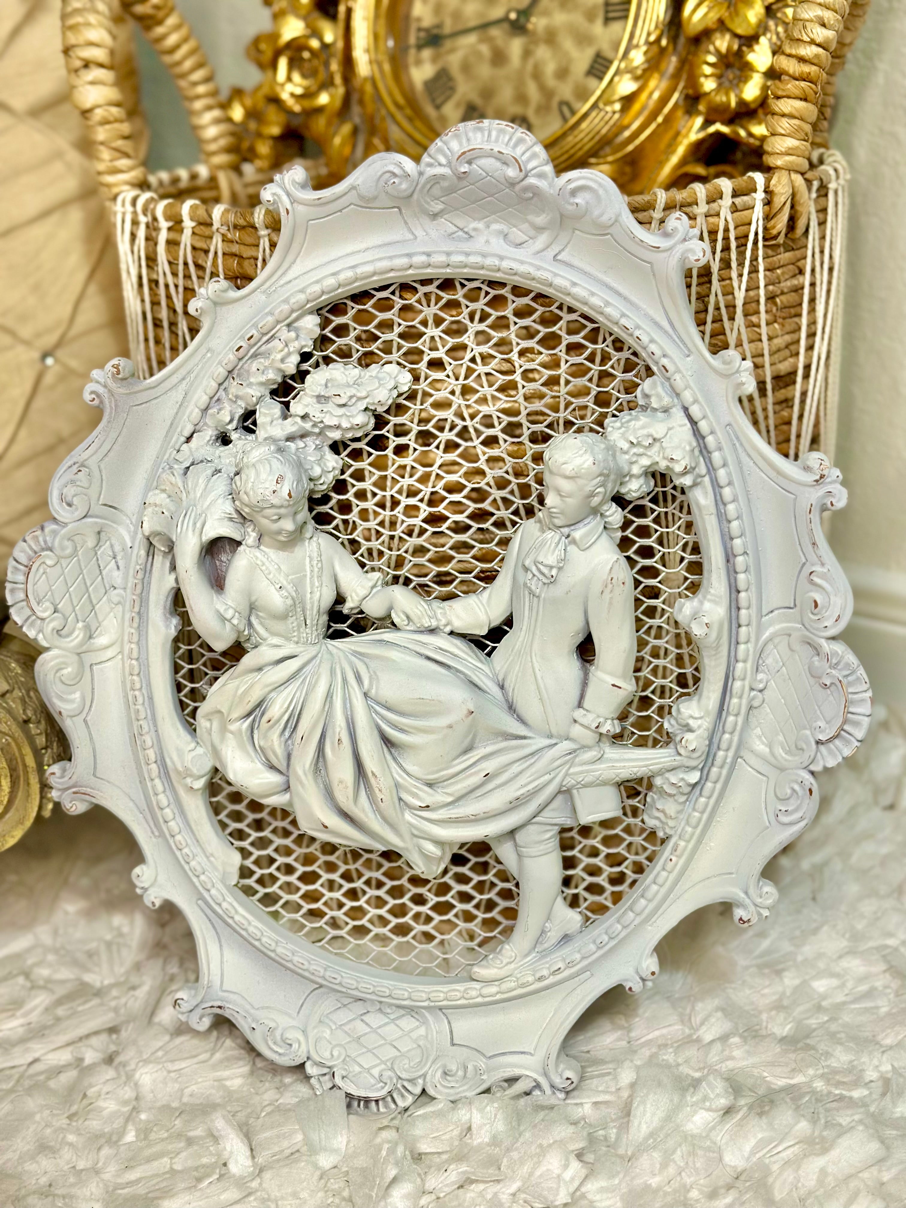 Pair of white wall plaques featuring Rococo colonial couple in vintage French style.