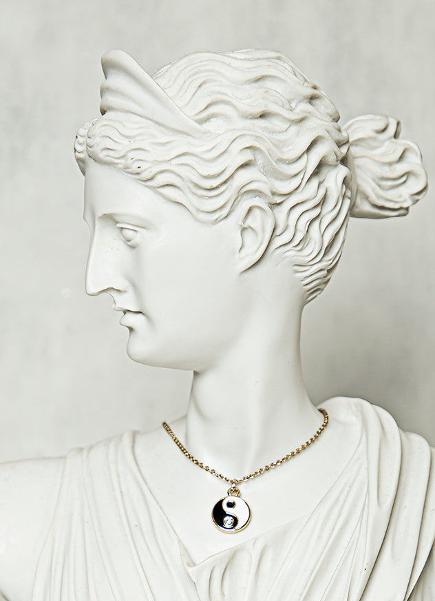 minimal gold yin and yang pendant necklace representing balance and spiritual harmony in modern style