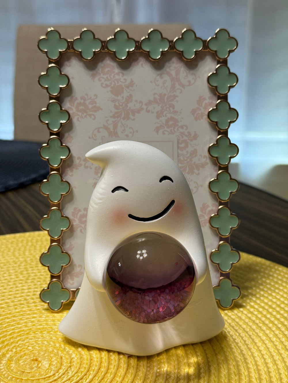 Decorative smily ghost figurine with a smiling face design on a textured surface