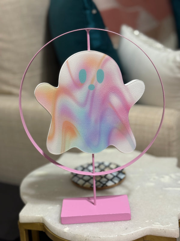 Colorful ghost-shaped decoration on a stand with a pink circular frame.