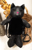 Black cat-shaped backpack with a pink heart on a white surface