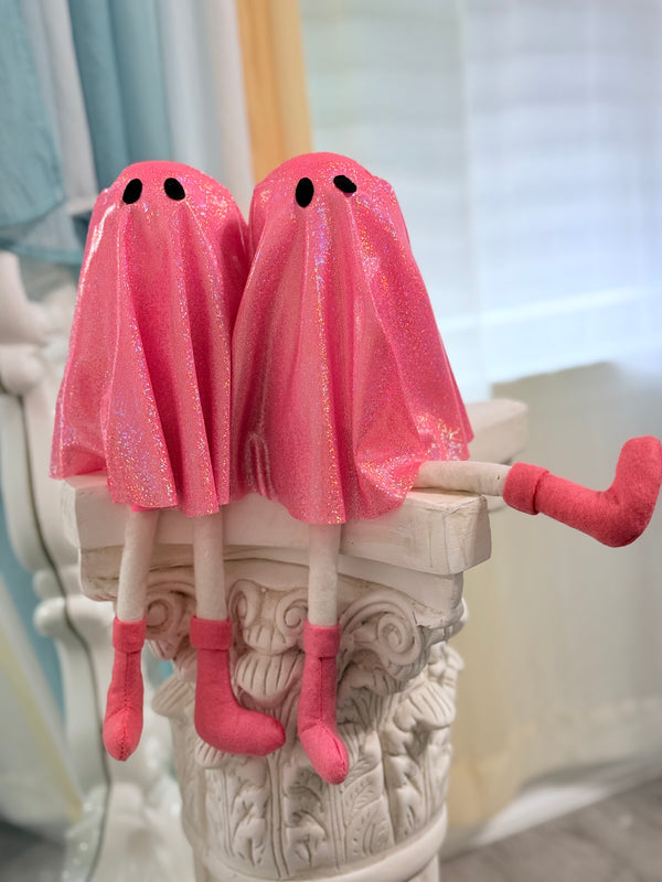 Two pink Rave ghost-shaped plush toys on a decorative column.