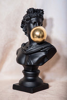 Black bust with a gold bubble on a beige background