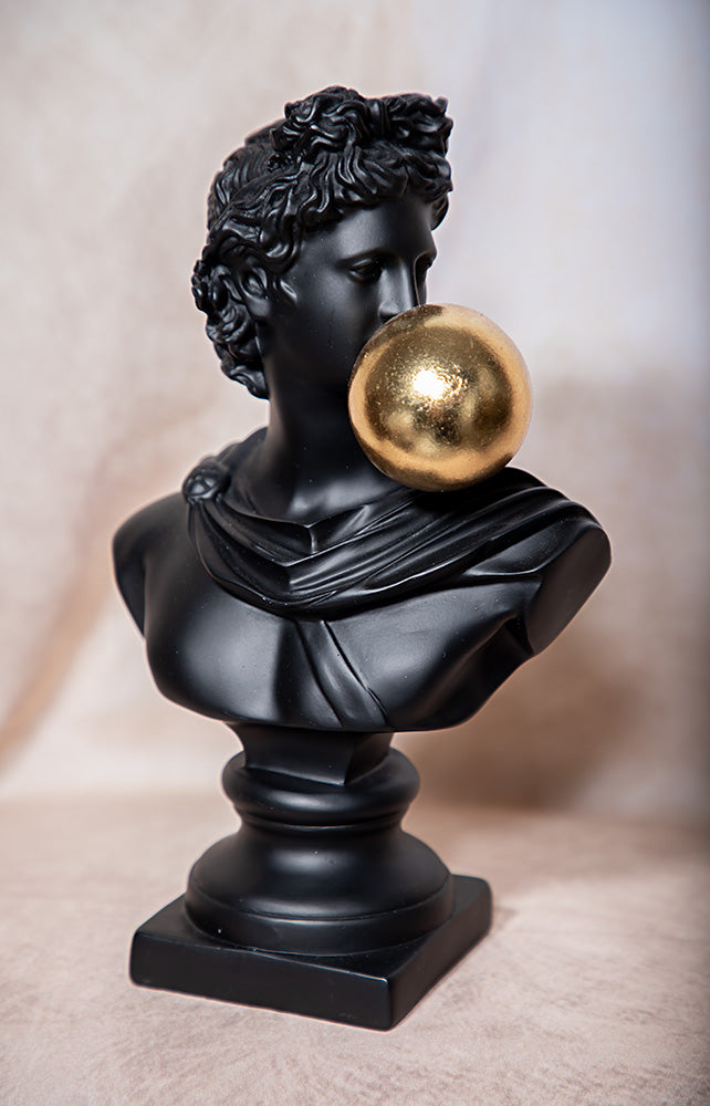 Black classical bust with a gold bubble on a neutral background