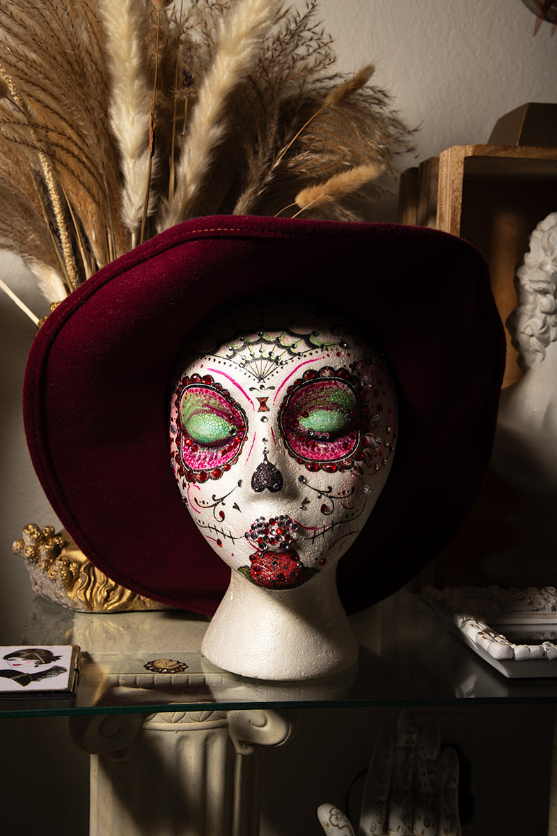 Hand-painted sugar skull art head featuring floral details, Mexican folk colors, and gothic Halloween style.