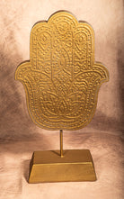 Antique gold Hamsa statue figurine with mandala engraving on stand, symbolic boho decor for spiritual spaces.