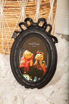 Gothic black oval picture frame with bow and ribbon detail, perfect for vintage or Halloween wall decor.

