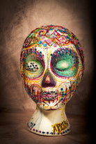 Handmade rhinestone sugar skull art head with colorful stones and intricate Mexican folk design.