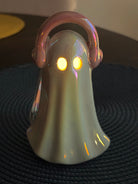 Holographic ghost figurine wearing pink headphones with LED light, fun retro music decor for Halloween display.