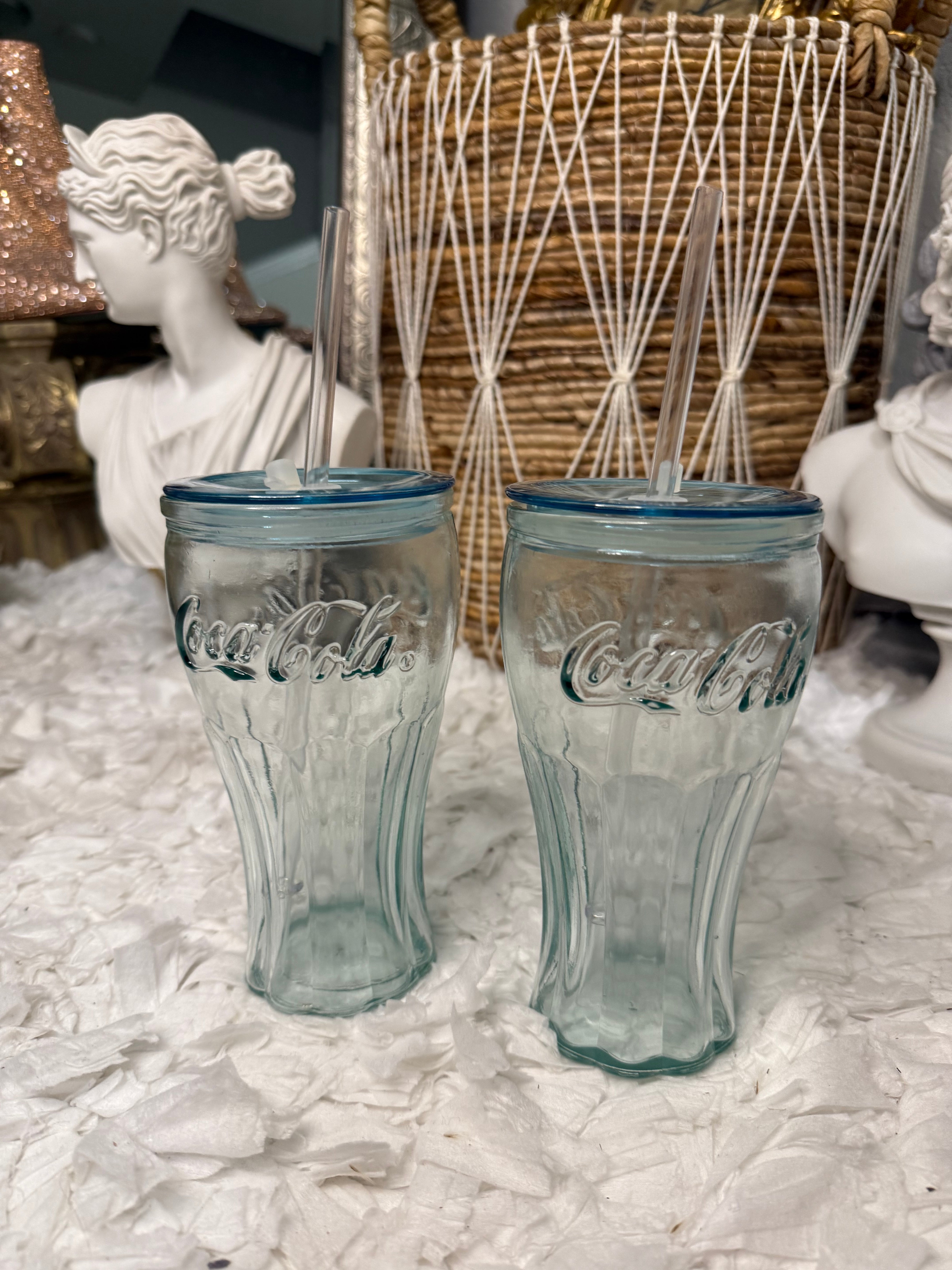 Pair of classic Coca-Cola glass bottles with embossed logo and straws, made in Spain.