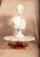 White scalloped marble cake stand with wooden base, perfect for elegant dessert display or home entertaining.
