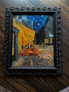 Ornate black baroque frame showcasing a textured café night canvas with raised brushstrokes and dramatic European street ambiance