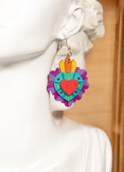 Colorful heart-shaped earrings on a statue