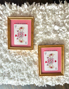 Two framed 'Queen of Hearts' playing card replicas on a textured white surface.