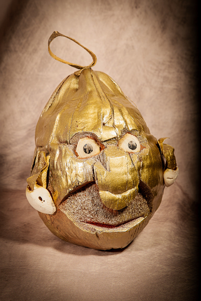 Vintage tiki-style coconut head sculpture painted gold for unique Halloween display.