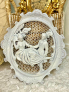 Pair of white wall plaques featuring Rococo colonial couple in vintage French style.