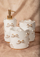 Three-piece white ceramic bathroom set with gold bow details, shabby chic Victorian decor.