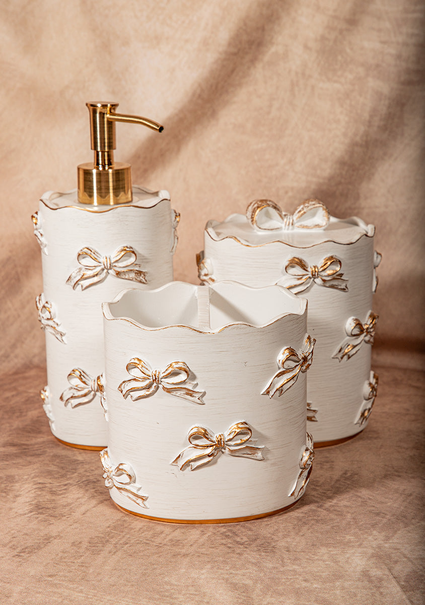 Three-piece white ceramic bathroom set with gold bow details, shabby chic Victorian decor.