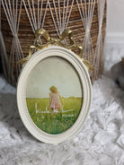 White and gold oval ribbon bow picture frame, vintage shabby chic home accent.