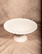 White porcelain fluted cake stand pedestal plate, elegant serving piece for desserts or home decor.
