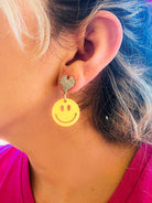 glitter yellow smiley face earrings with rhinestone heart design symbolizing happiness and rave style